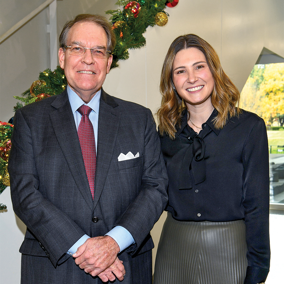 Two adults smiling together indoors near holiday décor during a Baylor Scott & White Foundation event.