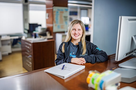 Kaylee Swaner smiling at the reception desk at Baylor Scott & White Dallas Foundation